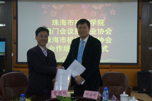 澳門會議展覽業協會理事長何海明（右）與珠海市技師學院副院長曾國熊（左）簽約後握手合照